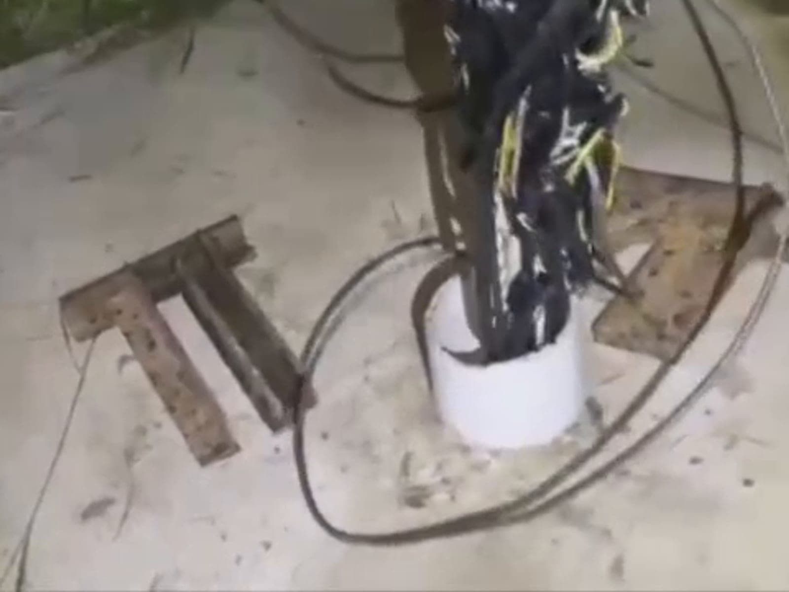 Gece, kuyu borusunun ağzından çıkan dolanmış siyah kablo ve boru demeti vinç bomuyla yukarı alınıyor